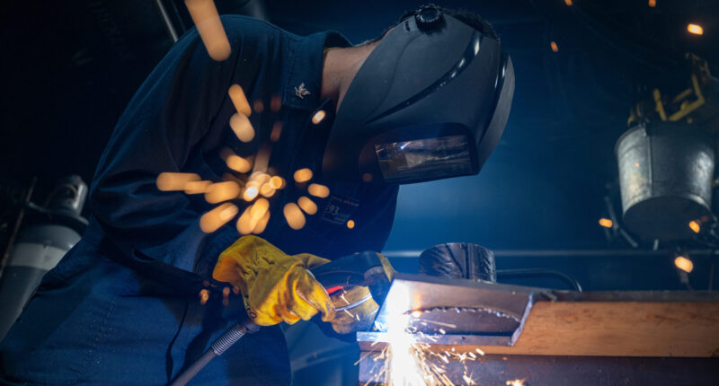 A technician cuts the baseplate of a 3D-printed vessel component