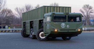 A large, green Chinese military prototype vehicle with multiple independent wheels designed to move sideways like a crab for transporting heavy missiles.