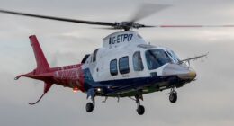 A QinetiQ helicopter in flight, featuring a critical component manufactured via 3D printing from recycled aircraft scrap metal.