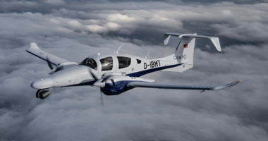 A twin-engine multi-mission aircraft operated by QinetiQ flying above cloud cover, configured for surveillance, test, and intelligence-gathering roles.
