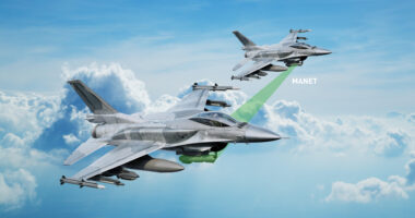 Two F-16 fighter jets flying in formation above the clouds, connected via a highlighted MANET data link for networked targeting and situational awareness.