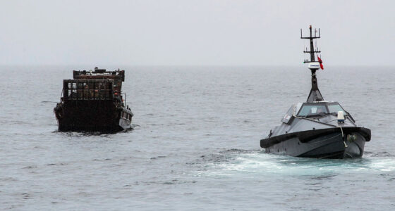 An autonomous surface vessel sea drone intercepts a cargo boat during a UK maritime security operation on open water