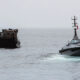 An autonomous surface vessel sea drone intercepts a cargo boat during a UK maritime security operation on open water