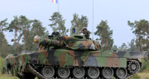 French Army Leclerc main battle tank draped in camouflage netting and flying the French tricolor during the Strong Europe Tank Challenge exercise, illustrating European armored warfare capability