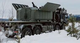 Rheinmetall Ragnarok 120mm truck-mounted mortar with open roof panels positioned in a winter landscape, showcasing its shoot-and-scoot mobile fires capability