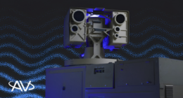 AV laser weapon system featuring a dual-aperture directed energy turret with blue accent lighting, mounted on a ground equipment stack against a dark particle-wave graphic background