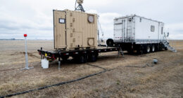 US Naval Research Laboratory mobile laser system on flatbed trailer deployed in field, used for power beaming and counter-UAS operations