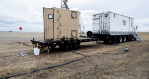 US Naval Research Laboratory mobile laser system on flatbed trailer deployed in field, used for power beaming and counter-UAS operations