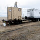 US Naval Research Laboratory mobile laser system on flatbed trailer deployed in field, used for power beaming and counter-UAS operations