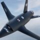 The MGI Engineering T-022 Vortex autonomous collaborative combat aircraft flying against a high-altitude blue sky, designed for UK manned-unmanned teaming operations.